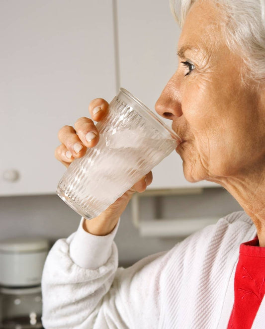 Trygga hemmet vattenanalys kvinna dricker vatten ur glas